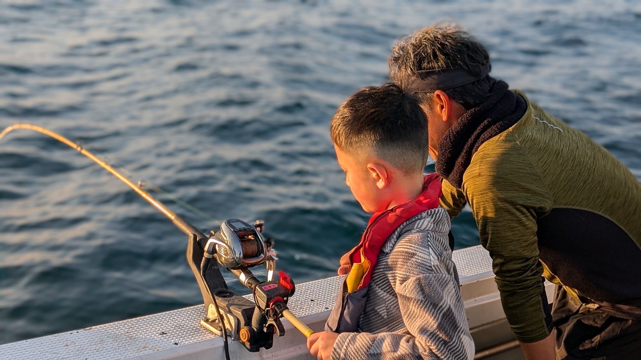 Dr. Baker fishing with his son at sunset