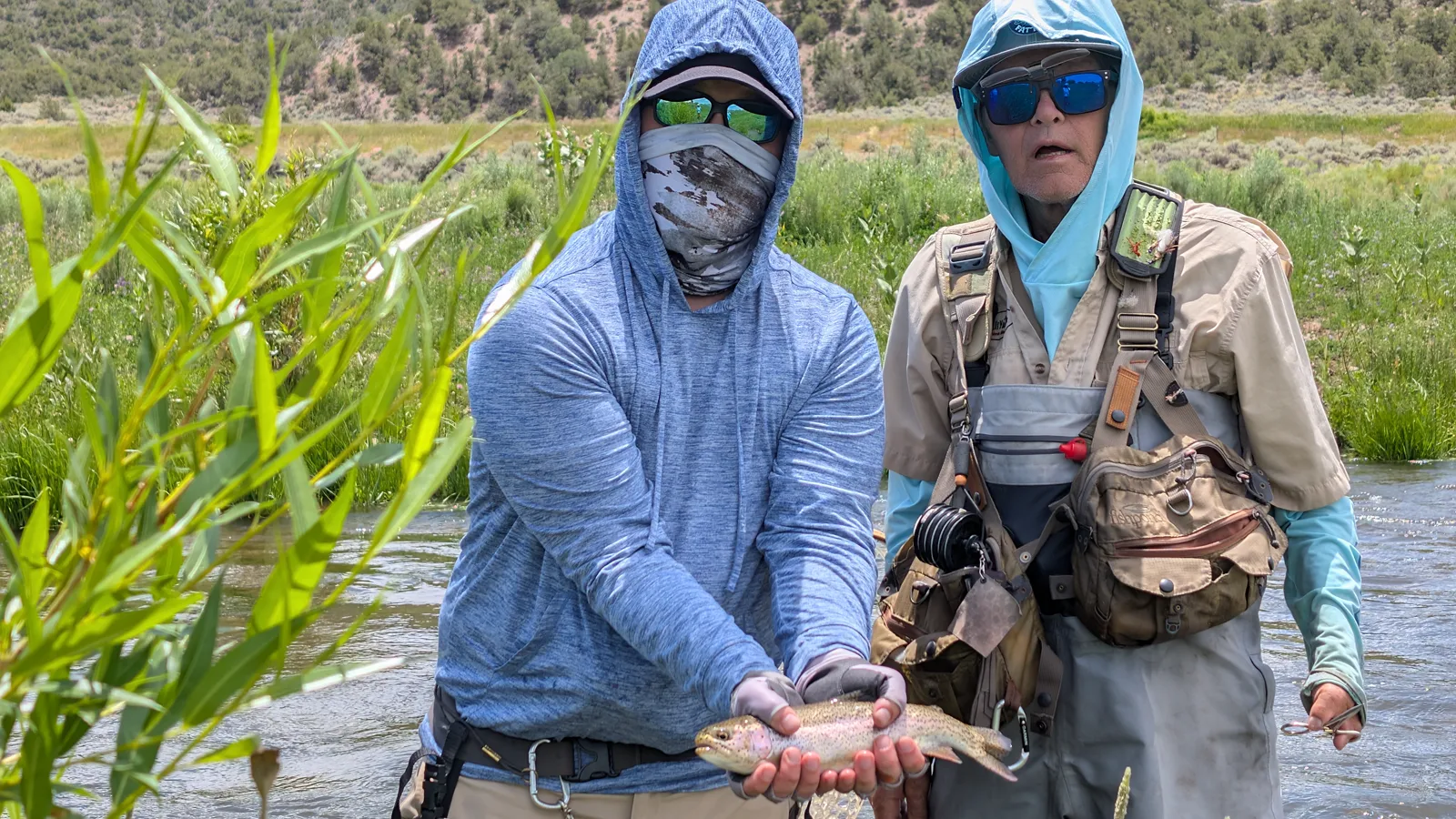 Holding up a trout on the bank